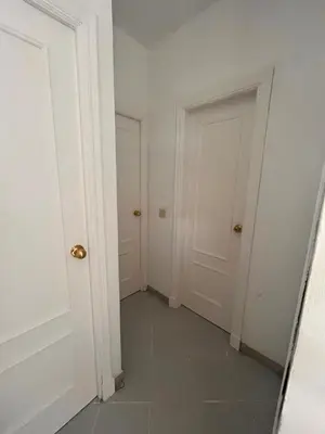 a hallway with two doors and a tile floor at PISO CENTRO HISTÓRICO 3 DORMITORIOS in Jerez de la Frontera
