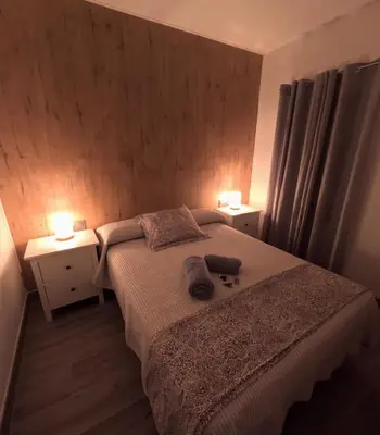 a bedroom with a bed with two night stands and two lamps at El rincon de Carmen in Jerez de la Frontera