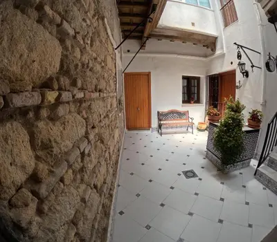 an empty hallway with a stone wall and a bench at El rincon de Carmen in Jerez de la Frontera