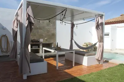 a patio with a hammock and a table at Finca La Garrocha in Conil de la Frontera