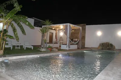 a swimming pool in front of a house at night at Finca La Garrocha in Conil de la Frontera