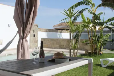 a table with a bottle of wine and a glass at Finca La Garrocha in Conil de la Frontera