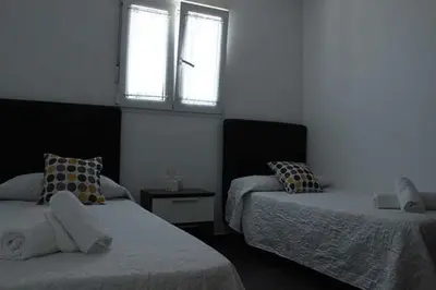 a bedroom with two beds and a window at Finca La Garrocha in Conil de la Frontera