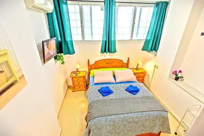 a small bedroom with a bed with blue pillows at Mercado Abastos Central Apartment in El Puerto de Santa María