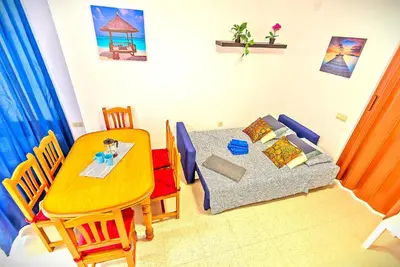 a living room with a table and a couch and a table and chairs at Mercado Abastos Central Apartment in El Puerto de Santa María