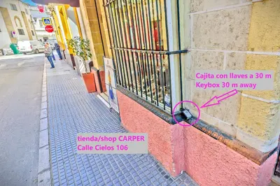 a sign on the side of a building with a pink ribbon at Mercado Abastos Central Apartment in El Puerto de Santa María