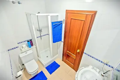 a small bathroom with a toilet and a shower at Mercado Abastos Central Apartment in El Puerto de Santa María