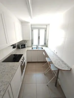 a white kitchen with a sink and a counter at Fortes holidays in Sanlúcar de Barrameda