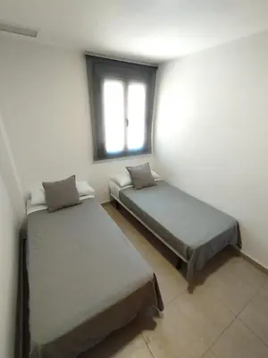 two beds in a room with a window at Fortes holidays in Sanlúcar de Barrameda