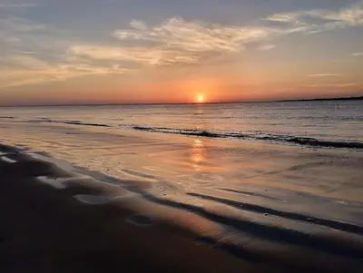a sunset on a beach with the ocean at Fortes holidays in Sanlúcar de Barrameda