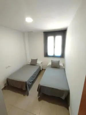 two beds in a room with a window at Fortes holidays in Sanlúcar de Barrameda