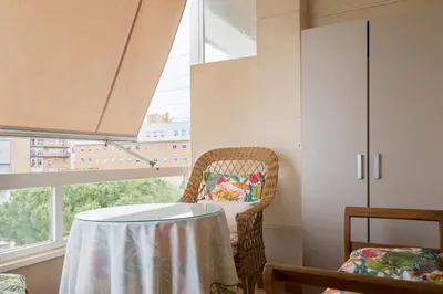 a table and chair in a room with a window at Maravilloso apartamento junto al mar a 5 km Cadiz in Puerto Real