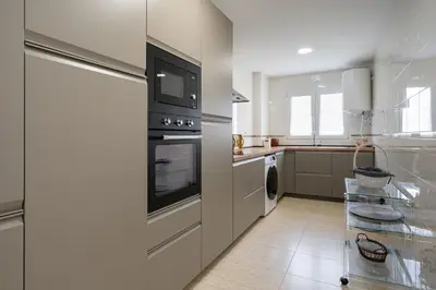 a kitchen with a stove and a refrigerator at Maravilloso apartamento junto al mar a 5 km Cadiz in Puerto Real