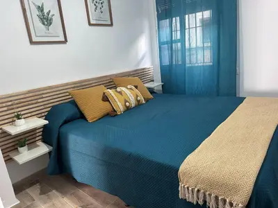 a bedroom with a blue bed with yellow pillows at TORREJÓN in Jerez de la Frontera