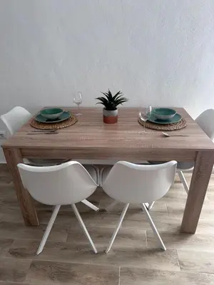 a wooden table with white chairs and a table with plates and glasses at TORREJÓN in Jerez de la Frontera