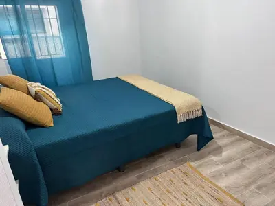 a blue bed in a room with a window at TORREJÓN in Jerez de la Frontera