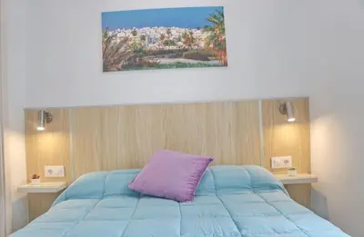 a bedroom with a blue bed with a purple pillow at Casa El Rellano in Hozanejos