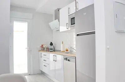 a kitchen with white cabinets and a refrigerator at Casa El Rellano in Hozanejos