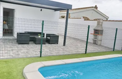 a fence with a swimming pool in front of a house at Casa El Rellano in Hozanejos