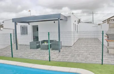 a fence with a pool in front of a house at Casa El Rellano in Hozanejos