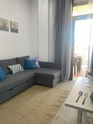 a living room with a couch and a table at Apartamento Barrosa Beach in Chiclana de la Frontera