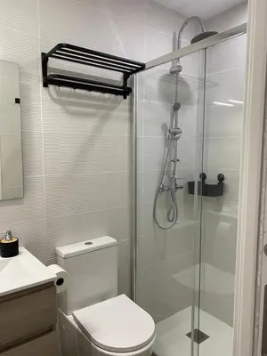 a bathroom with a toilet and a glass shower at Apartamento Barrosa Beach in Chiclana de la Frontera