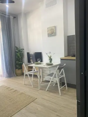 a dining room with a white table and chairs at Apartamento Barrosa Beach in Chiclana de la Frontera