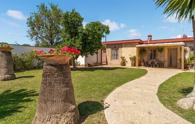 a house with a garden with a flower pot on a tree at Nice Home In Chiclana De La Fronter in Chiclana de la Frontera