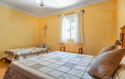 a bedroom with two beds and a window at Nice Home In Chiclana De La Fronter in Chiclana de la Frontera