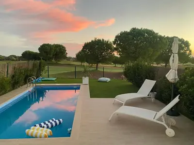 a swimming pool with two chairs and a pool at Cadiz Golf & Beach in Barrio de Jarana