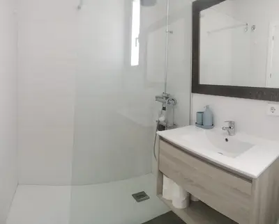 a white bathroom with a sink and a shower at Cadiz Golf & Beach in Barrio de Jarana