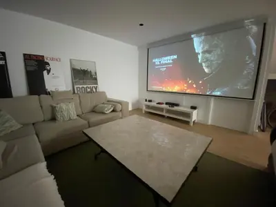 a living room with a couch and a large screen at Cadiz Golf & Beach in Barrio de Jarana