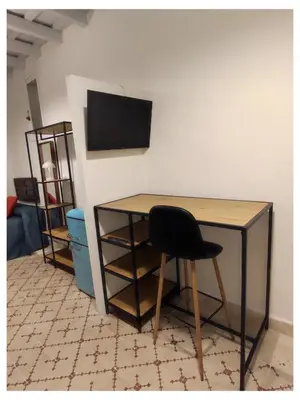 a desk with a chair and a television on a wall at La Baraka Apartamentos 2 in Jerez de la Frontera