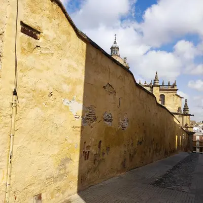 an old wall with a building in the background at La Baraka Apartamentos 2 in Jerez de la Frontera