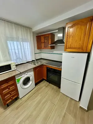 a kitchen with a white refrigerator and a washing machine at Apartamento de Encanto in San Fernando