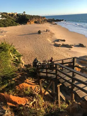 a group of people sitting on a bench on a beach at Villa Alegría in Roche