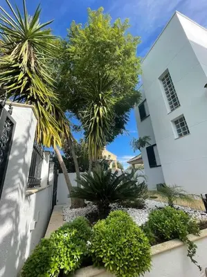 a white building with trees and plants in front of it at Sunset Villa Arcos in Arcos de la Frontera