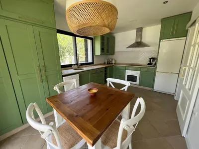 a kitchen with green cabinets and a wooden table and chairs at Sunset Villa Arcos in Arcos de la Frontera