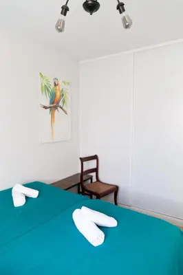 a bedroom with a green bed with towels on it at Casa Amelí by Gades Gestión in Cádiz