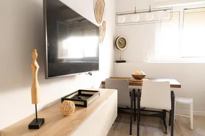 a dining room with a table and a tv on a wall at Casa Amelí by Gades Gestión in Cádiz