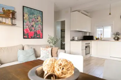 a living room and kitchen with a table and a couch at Casa Amelí by Gades Gestión in Cádiz