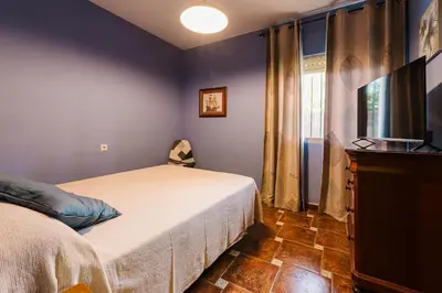 a bedroom with a bed and a flat screen tv at Precioso Chalet Atlántida solo familias in Roche