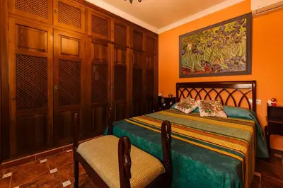 a bedroom with a bed and two chairs in it at Precioso Chalet Atlántida solo familias in Roche