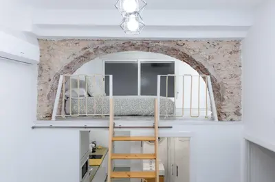 a bedroom with a bunk bed in a room with a brick wall at Falla Suite Bajo in Cádiz
