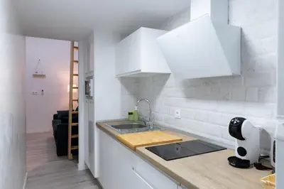 a white kitchen with a sink and a counter top at Falla Suite Bajo in Cádiz