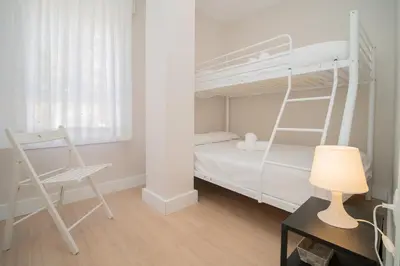 a bedroom with a bunk bed and a desk with a lamp at Sibs Sanlucar Maestrante Centrico Ideal Familias in Sanlúcar de Barrameda