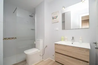 a bathroom with a toilet and a sink and a mirror at Sibs Sanlucar Maestrante Centrico Ideal Familias in Sanlúcar de Barrameda