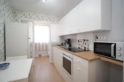 a kitchen with white cabinets and a microwave at Sibs Sanlucar Maestrante Centrico Ideal Familias in Sanlúcar de Barrameda