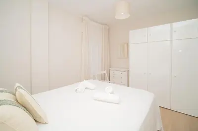 a white bedroom with a white bed and white cabinets at Sibs Sanlucar Maestrante Centrico Ideal Familias in Sanlúcar de Barrameda