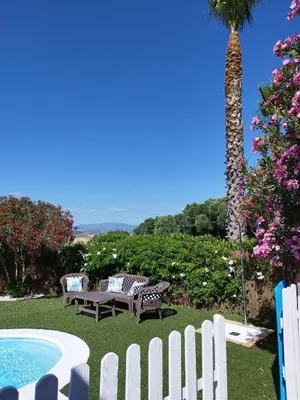 a white fence and a bench next to a pool at Vivienda Rural Los Madroños in Malcocinado